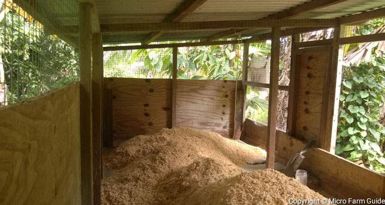 chicken coop with mound of wood shavings